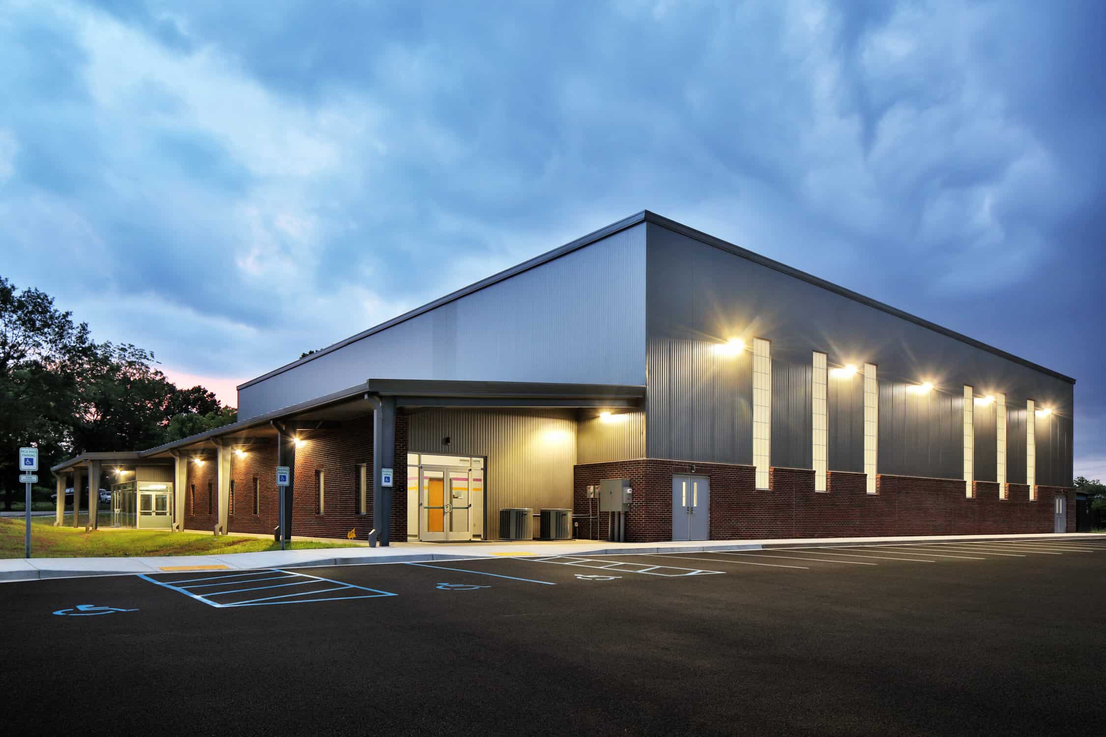 Exterior of large warehouse gym building at night